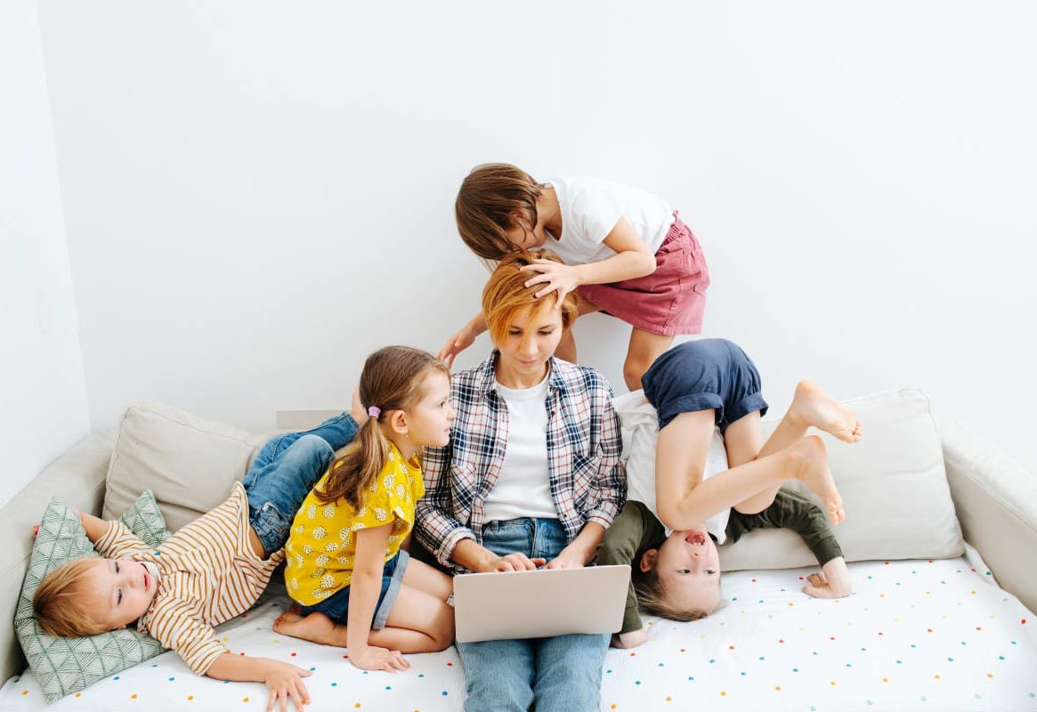 жинка працює на ноутбуці поряд діти опублікувати статтю